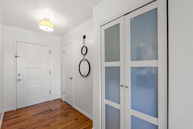 entryway featuring baseboards and wood finished floors