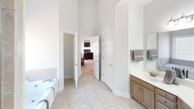 bathroom featuring tile patterned flooring, a towering ceiling, vanity, and a tub to relax in