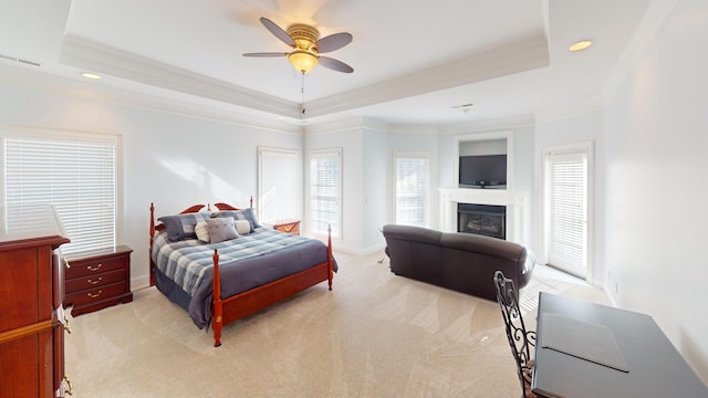 carpeted bedroom featuring ceiling fan, a raised ceiling, and crown molding