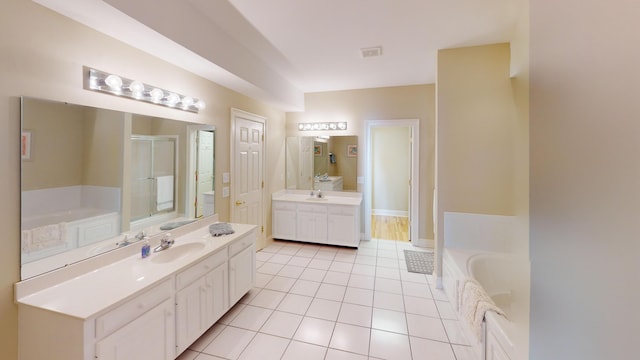 bathroom featuring a tub to relax in, tile patterned flooring, and vanity