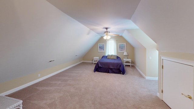 unfurnished bedroom with ceiling fan, light carpet, and vaulted ceiling