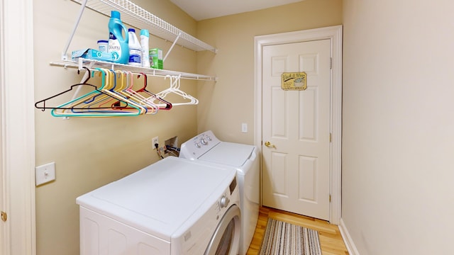 washroom with washing machine and dryer and light wood-type flooring