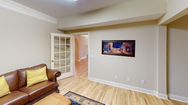 sitting room with hardwood / wood-style flooring and crown molding