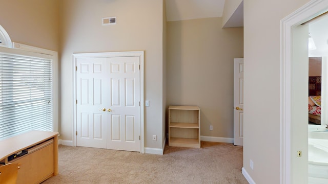 bedroom with light carpet, connected bathroom, and a closet