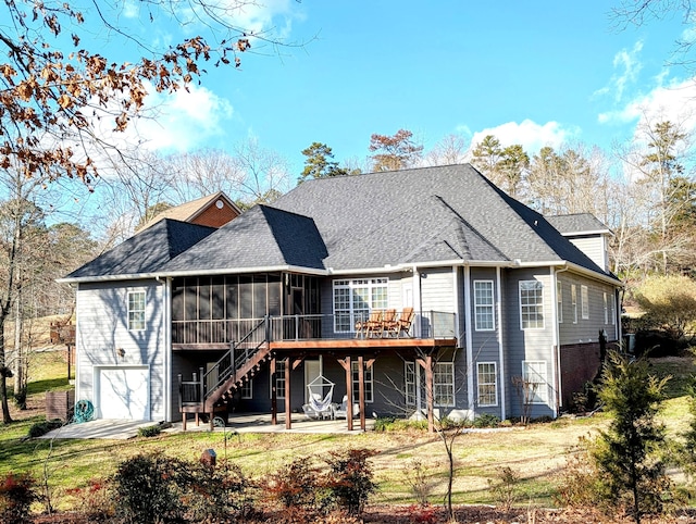 back of house featuring a patio, a lawn, a wooden deck, a garage, and a sunroom