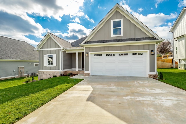 craftsman house with driveway, an attached garage, fence, a front lawn, and board and batten siding