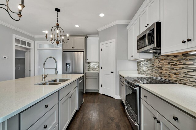 kitchen featuring decorative backsplash, sink, an inviting chandelier, hanging light fixtures, and stainless steel appliances