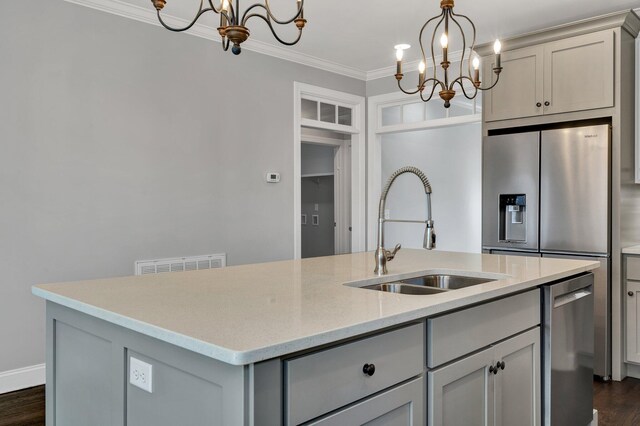 kitchen with sink, gray cabinets, a chandelier, and an island with sink