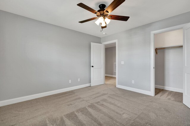 unfurnished bedroom featuring ceiling fan, light colored carpet, and a closet