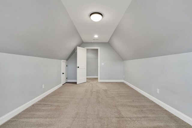 additional living space with light carpet and lofted ceiling