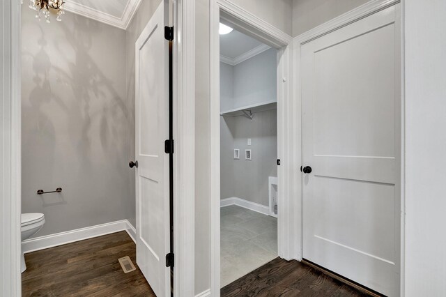 laundry area featuring dark hardwood / wood-style flooring and ornamental molding