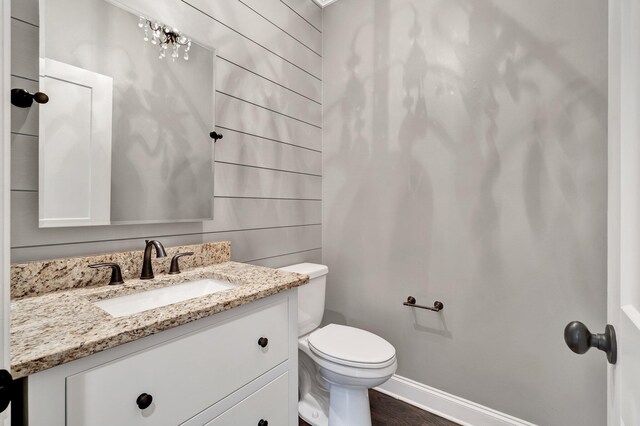 bathroom with wood-type flooring, toilet, and vanity