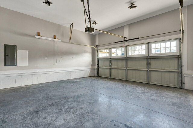 garage with electric panel and a garage door opener