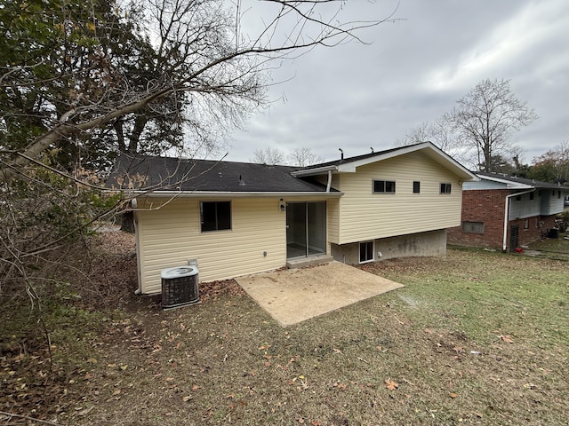 rear view of house with cooling unit, a yard, and a patio