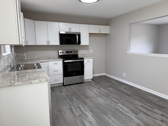 kitchen featuring white cabinetry, sink, light stone countertops, and stainless steel range with electric stovetop