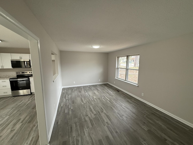 spare room with a textured ceiling and hardwood / wood-style flooring