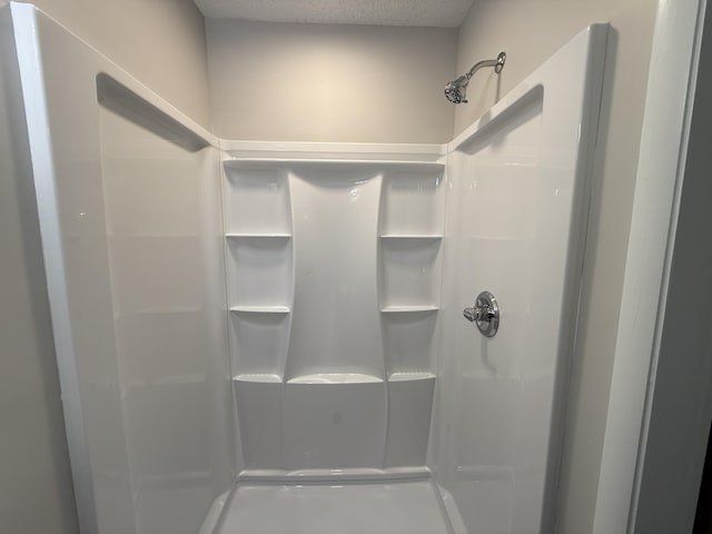 bathroom with a textured ceiling and walk in shower