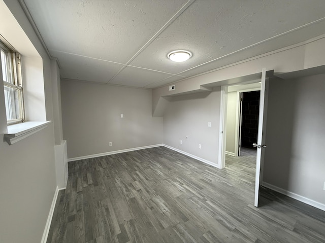 basement with dark hardwood / wood-style flooring and a textured ceiling