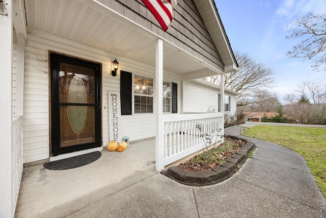 doorway to property with a porch and a yard