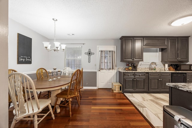 dining area featuring sink, dark hardwood / wood-style flooring, a textured ceiling, and a notable chandelier