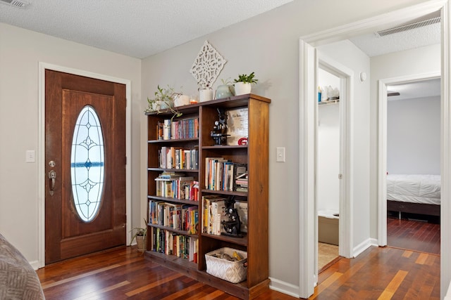 foyer with a textured ceiling and dark hardwood / wood-style floors