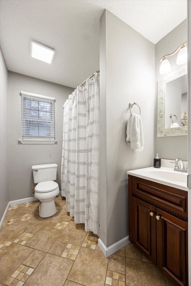 bathroom with vanity, a textured ceiling, and toilet