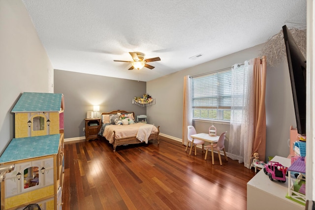 bedroom featuring a textured ceiling, ceiling fan, and dark hardwood / wood-style floors