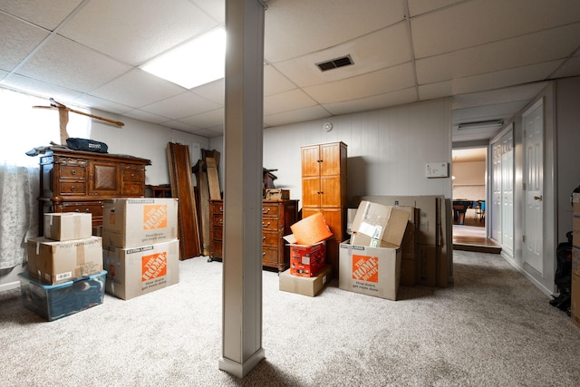 basement featuring a paneled ceiling and carpet floors