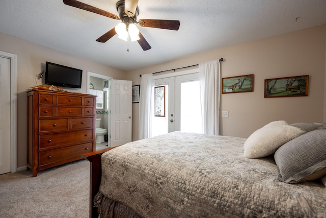 carpeted bedroom with french doors, a textured ceiling, ensuite bathroom, and ceiling fan