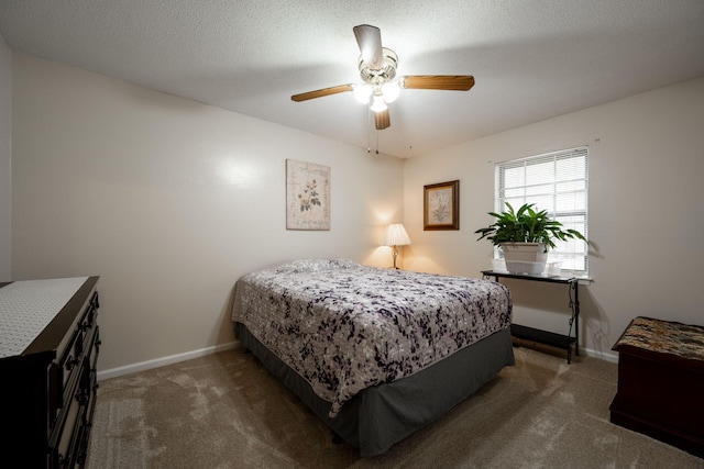 bedroom featuring ceiling fan, a textured ceiling, and dark colored carpet