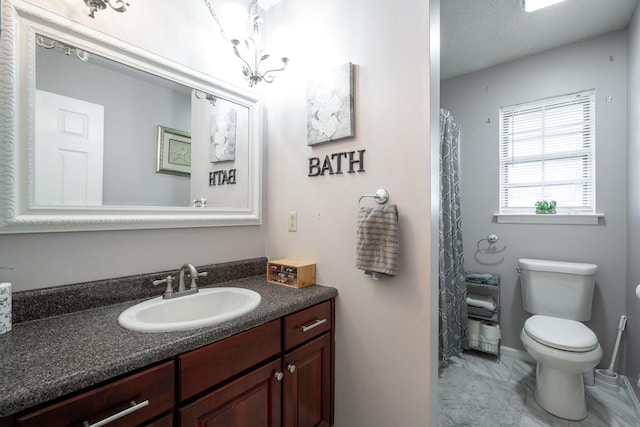 bathroom featuring vanity, toilet, and a notable chandelier