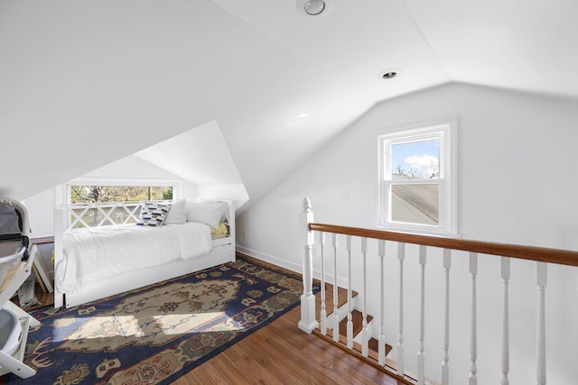 bedroom featuring dark hardwood / wood-style floors, lofted ceiling, and multiple windows