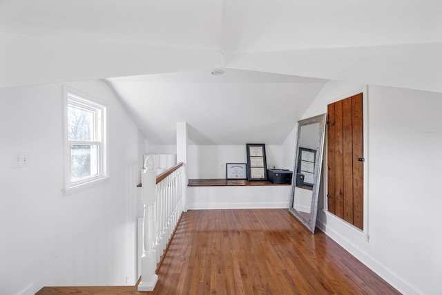 additional living space with hardwood / wood-style flooring and lofted ceiling