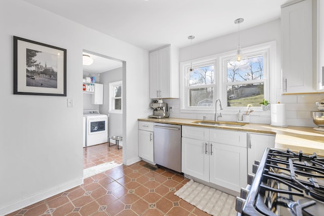 kitchen featuring backsplash, white cabinets, sink, washer / dryer, and stainless steel appliances