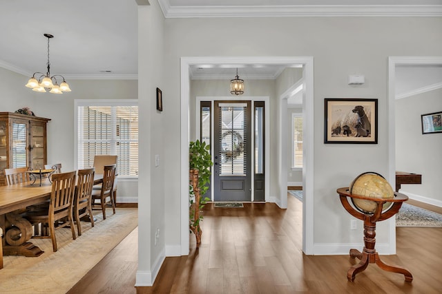 foyer featuring an inviting chandelier, plenty of natural light, and ornamental molding