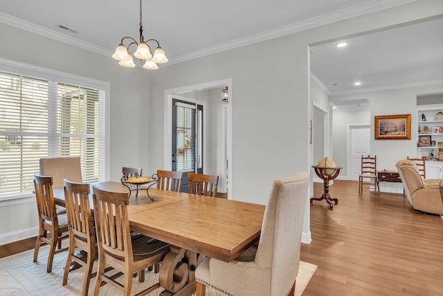 dining room featuring an inviting chandelier, crown molding, and light hardwood / wood-style flooring