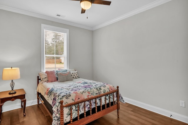 bedroom featuring hardwood / wood-style floors, ornamental molding, and ceiling fan