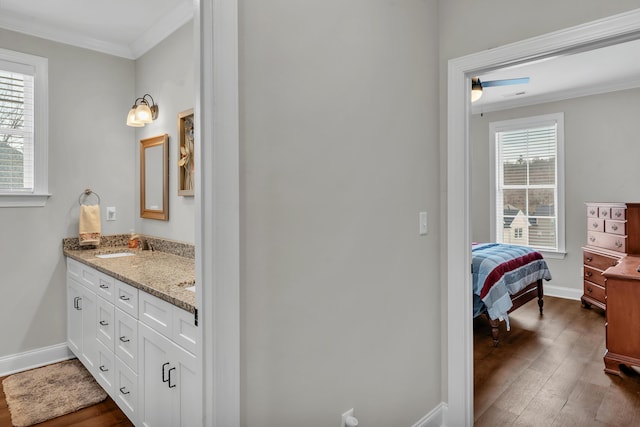 bathroom with crown molding, wood-type flooring, vanity, and ceiling fan