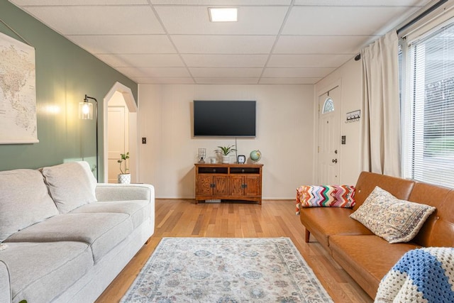 living room featuring light hardwood / wood-style flooring and a drop ceiling