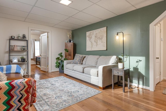 living room with a paneled ceiling and hardwood / wood-style flooring