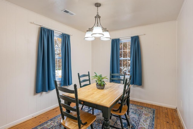 dining room with wood-type flooring and crown molding