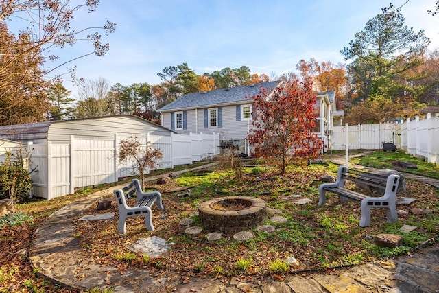 rear view of house featuring a fire pit and a shed