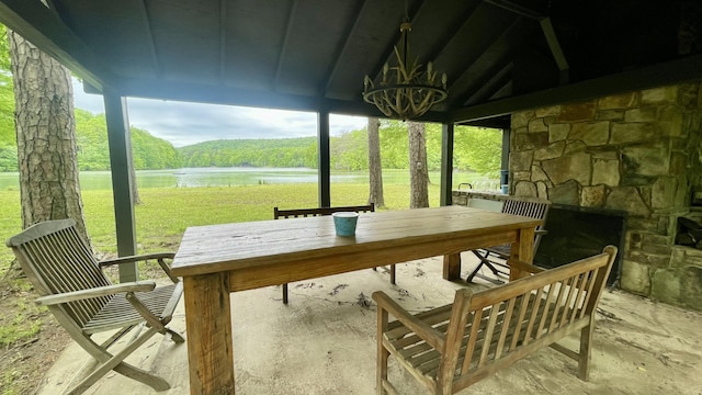 sunroom featuring a water view