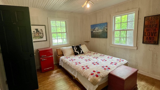 bedroom featuring hardwood / wood-style flooring, multiple windows, and wood ceiling