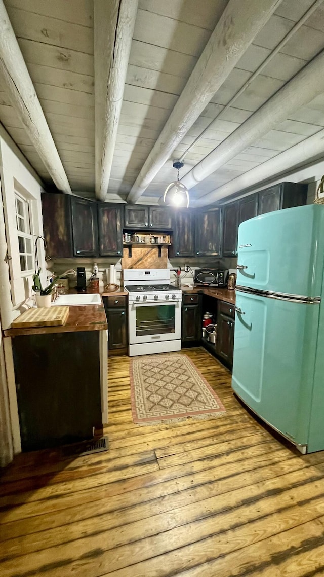 kitchen with wood counters, sink, light hardwood / wood-style flooring, white gas range, and fridge