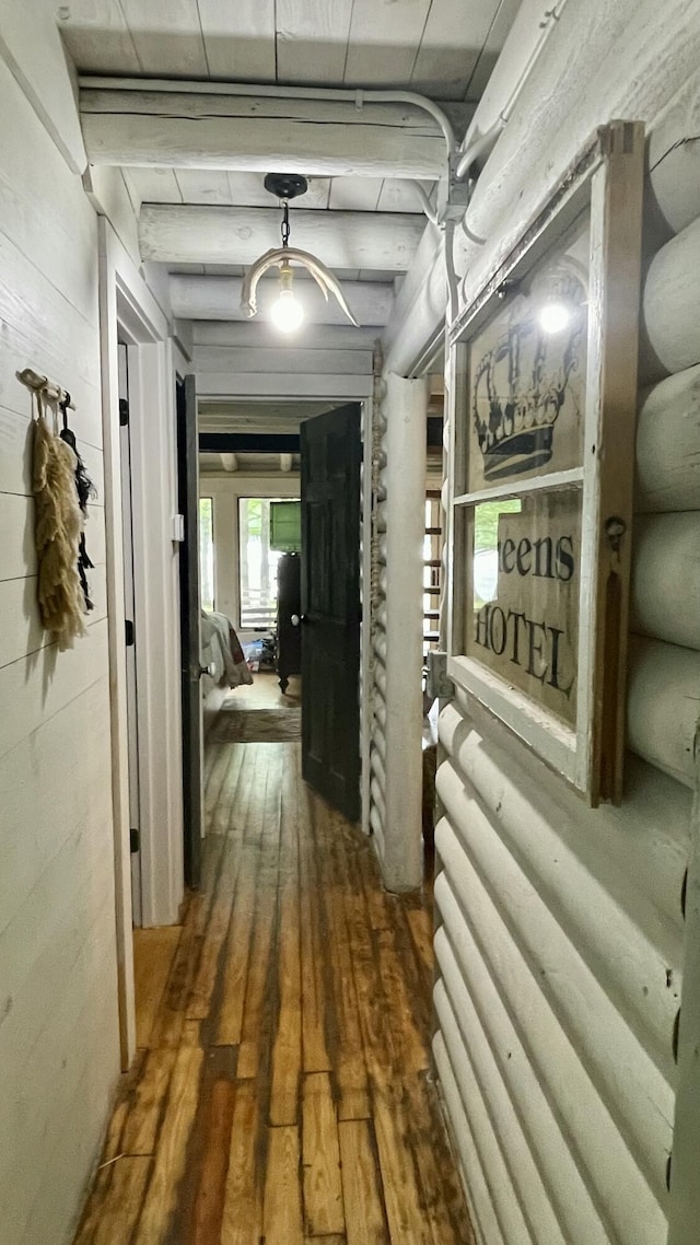 hall featuring beamed ceiling and dark hardwood / wood-style floors