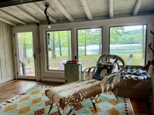 sunroom featuring a healthy amount of sunlight, a water view, and wooden ceiling