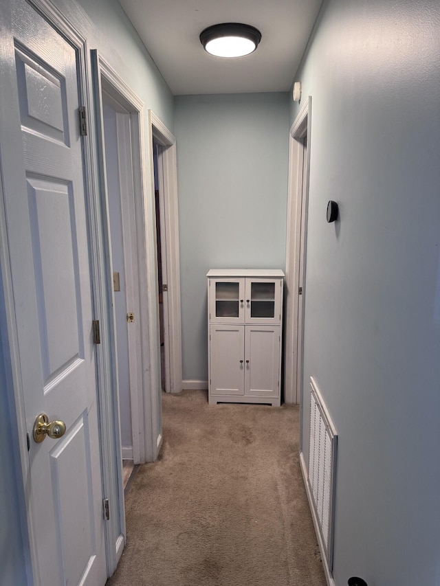 hallway featuring light colored carpet