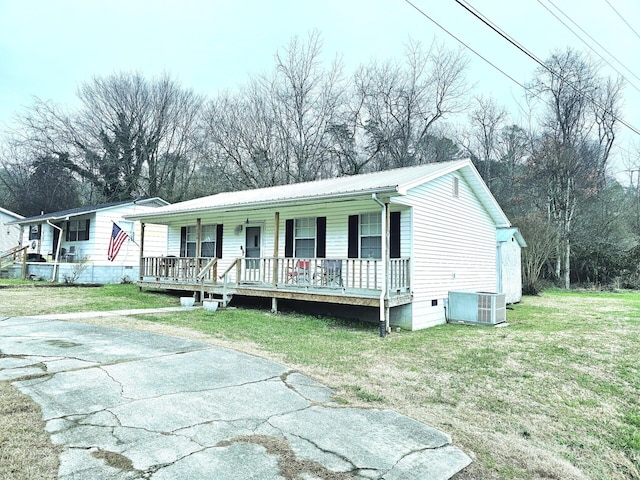 view of front of home with covered porch, central AC unit, and a front lawn