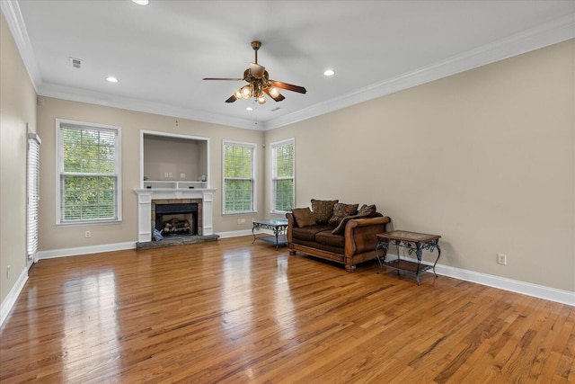 living room featuring light hardwood / wood-style flooring, crown molding, ceiling fan, and a healthy amount of sunlight